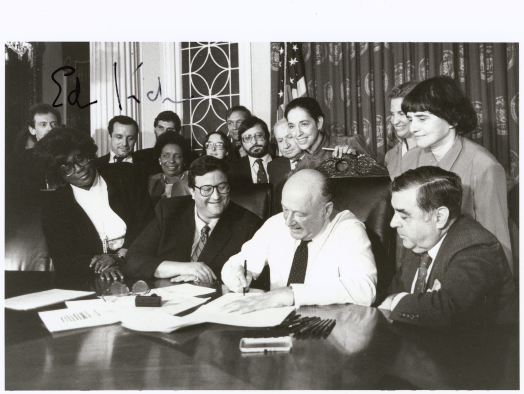 Black and white photograph of Mayor Koch signing Gay Rights bill at his desk.