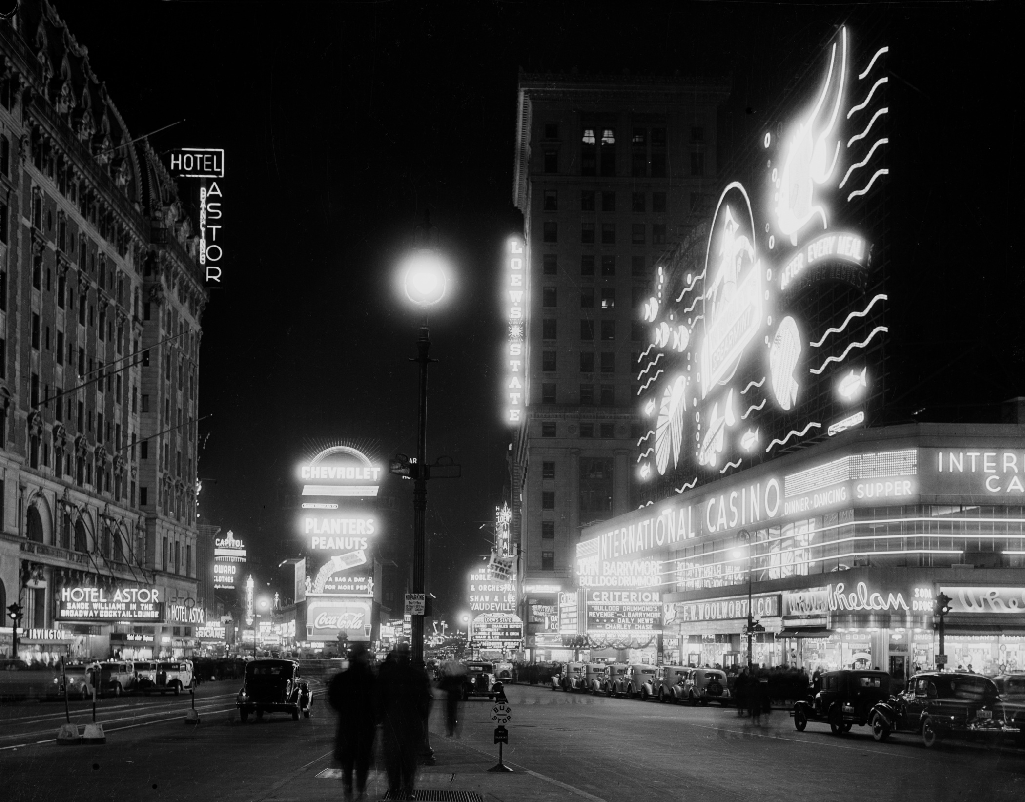 Nighttime view of Times Square illuminated by bright billboards and bustling city traffic.